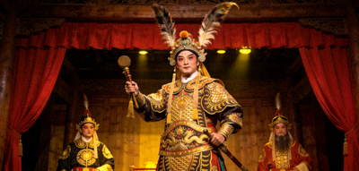 传统戏剧演员在古色古香的舞台上表演，服饰华丽