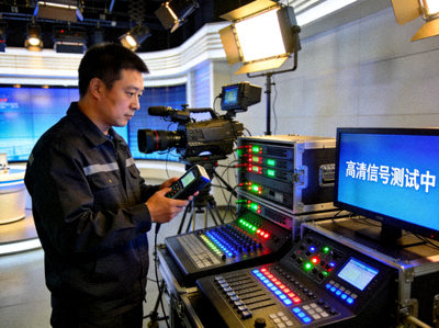 技术负责人张伟在演播室检查高清直播设备与信号